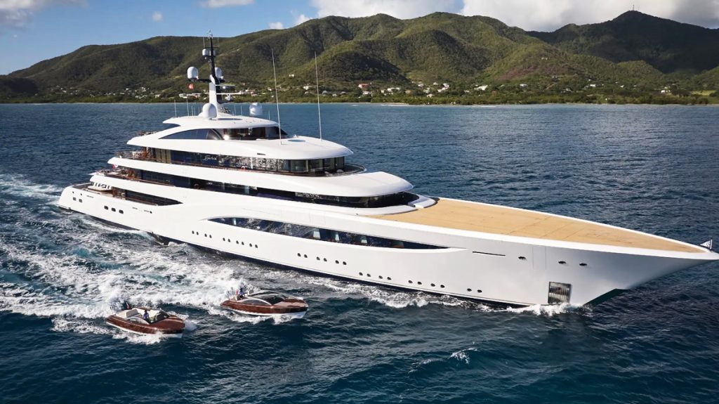 Super yacht in ocean and two boats